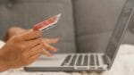 Persoon gebruikt creditcard op laptop voor veilig online winkelen